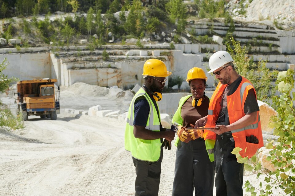 Site foreman and workers discussing plans at a quarry site