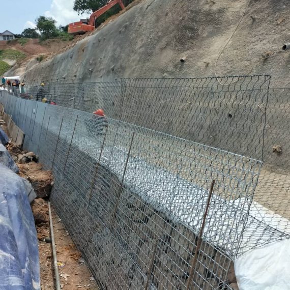 Wire mesh slope facing under construction at a cut slope site