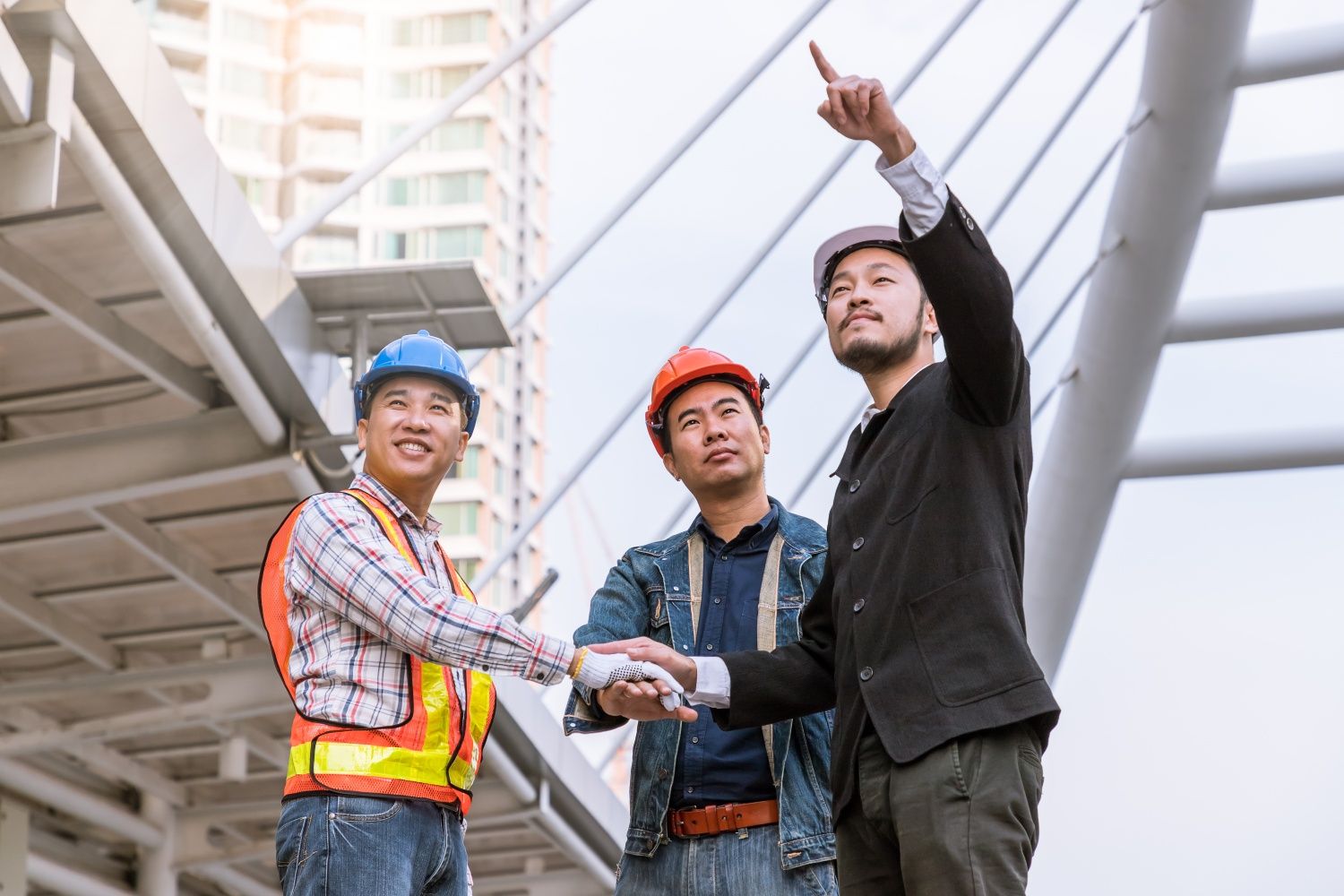 Team of engineers reviewing plans at a construction site